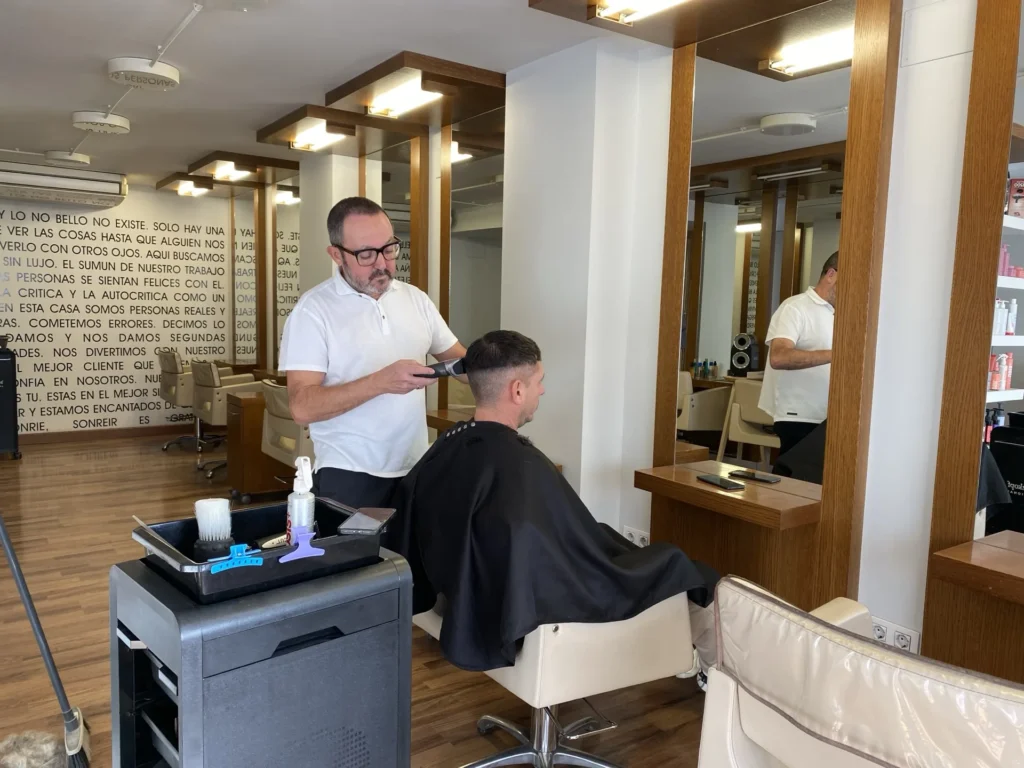 Enrique Ferrándiz cortando el pelo a un cliente en el salón